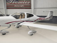 White single-engine propeller plane with T-tail in hangar at Premier Aircraft, registration N162UA.