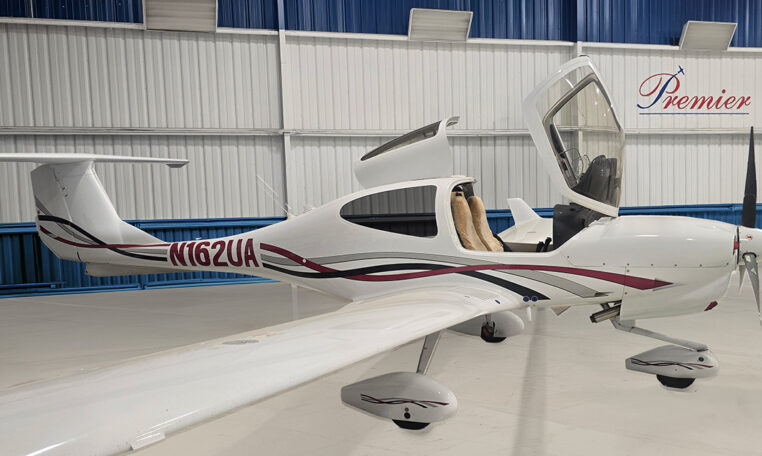 Diamond DA20 single-engine trainer aircraft in hangar with open canopy, tail number N162UA