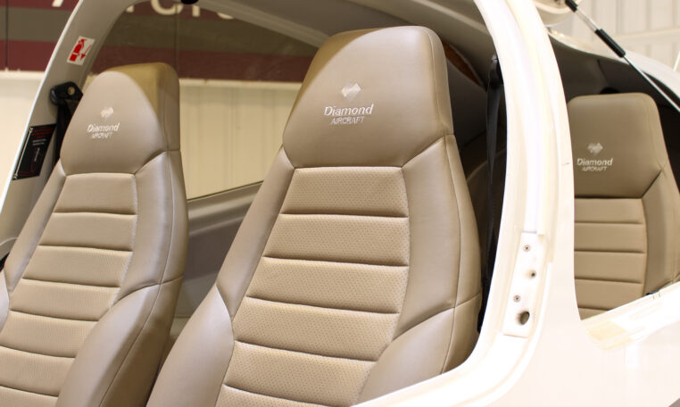 Diamond Aircraft cockpit interior with tan leather seats and stitching detail in light aircraft cabin.