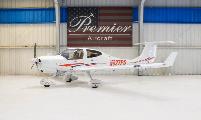 White single-engine light aircraft N627PS in Premier Aircraft hangar, side view with T-tail and propeller, for sale