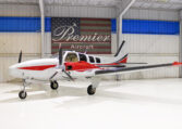 Red and white twin-engine propeller aircraft in a bright hangar at Premier Aircraft