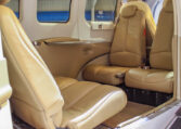 Private plane interior with tan leather seats and spacious cabin, view from open door, luxury air travel seating