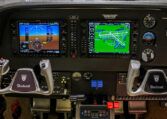 Beechcraft cockpit with Garmin G1000 dual displays, yokes, and avionics controls in a light twin-engine aircraft