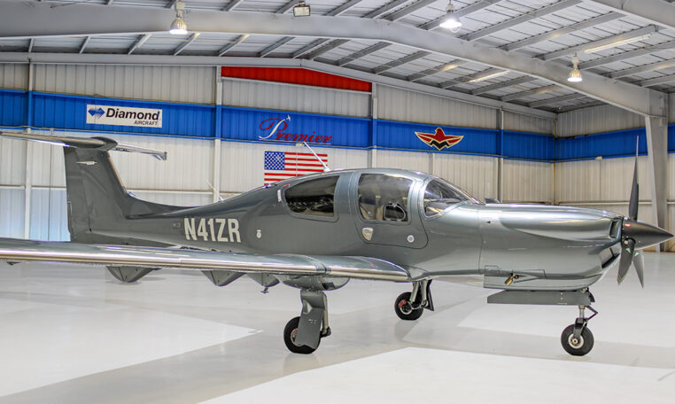 Gray Diamond Aircraft single-engine prop plane N41ZR parked in a bright Premier hangar.