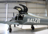 Gray Cirrus SR22 single-engine plane in hangar with gullwing doors open, N41ZR visible, modern private aircraft interior.