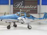 Blue Diamond DA62 twin-engine propeller airplane in hangar at Premier Aircraft, front three-quarter view