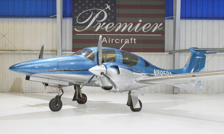 Blue Diamond DA62 twin-engine propeller airplane in hangar at Premier Aircraft, front three-quarter view