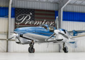 Sleek blue and silver twin-engine propeller aircraft in hangar at Premier, polished plane ready for sale or charter.