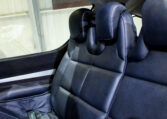 Luxury car rear seats in black perforated leather with adjustable headrests and contrast stitching, premium interior.