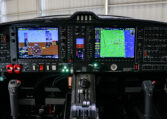 Glass cockpit avionics panel of a small aircraft with Garmin PFD/MFD displays, autopilot controls, and throttle quadrant.