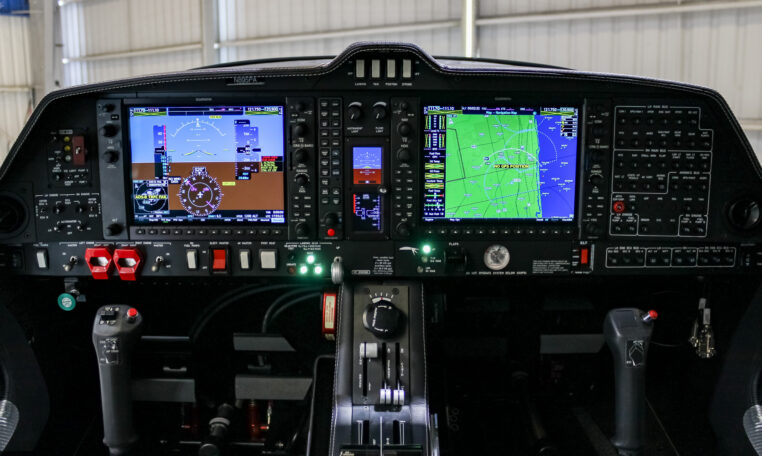 Glass cockpit avionics panel of a small aircraft with Garmin PFD/MFD displays, autopilot controls, and throttle quadrant.