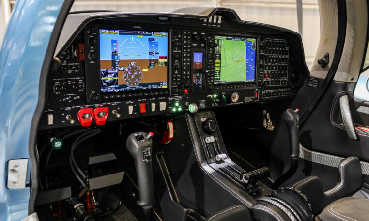 Cirrus SR22 glass cockpit with dual Garmin avionics displays, side-stick controls, and center console throttle.