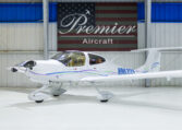 White single-engine private propeller aircraft N963DS in Premier Aircraft hangar showroom