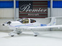 White single-engine private propeller aircraft N963DS in Premier Aircraft hangar showroom