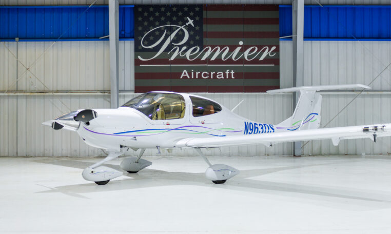 White single-engine private propeller aircraft N963DS in Premier Aircraft hangar showroom