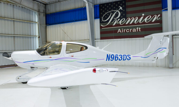 White low-wing single-engine aircraft N963DS in Premier Aircraft hangar, sleek design with tinted canopy.