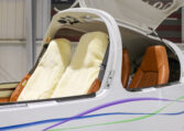 Diamond DA40 aircraft cockpit with sheepskin front seats, tan leather rear seats, open canopy in hangar