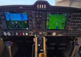 Modern airplane cockpit with Garmin glass avionics, PFD/MFD displays, navigation map, and flight controls.