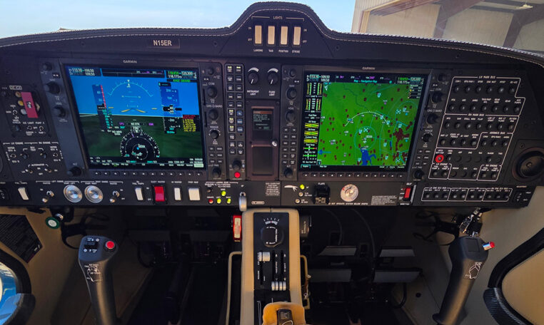 Modern airplane cockpit with Garmin glass avionics, PFD/MFD displays, navigation map, and flight controls.