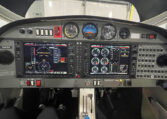 Airplane cockpit instrument panel with dual glass avionics displays, gauges and switches inside single-engine light aircraft.