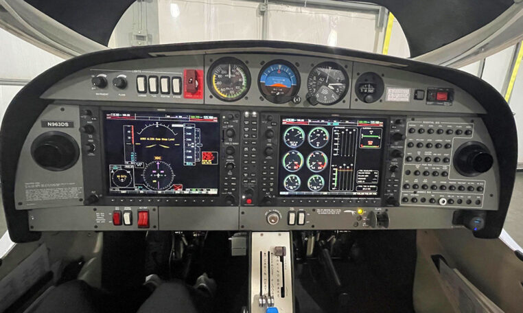 Airplane cockpit instrument panel with dual glass avionics displays, gauges and switches inside single-engine light aircraft.