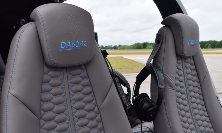 Diamond DA50 RG cockpit with gray leather seats and headset, luxury light aircraft interior on runway