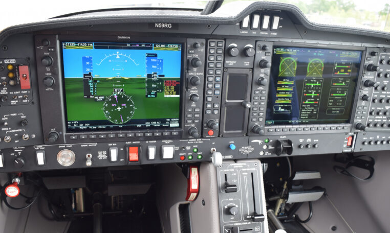 Modern airplane cockpit with Garmin glass cockpit avionics, dual displays, flight instruments and controls.