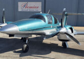 Teal Diamond DA62 twin-engine airplane parked at Premier Aircraft Sales hangar, nose-on view with propellers.