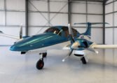 Teal and white twin-engine propeller airplane in hangar—modern private aircraft ready for flight, aviation and charter.