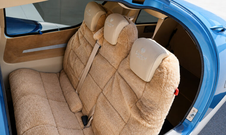 Diamond Aircraft sheepskin rear seats inside blue single-engine airplane interior, tan upholstery and seatbelts