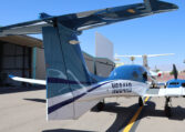 Sleek blue-and-white twin-engine private aircraft on tarmac by hangars, N684AB tail number visible