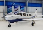 Piper Saratoga II TC single-engine piston airplane in hangar, white and blue livery, registration N614DM at Premier