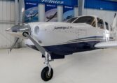 Piper Saratoga II TC single-engine propeller airplane parked in hangar, close-up nose and cockpit view.