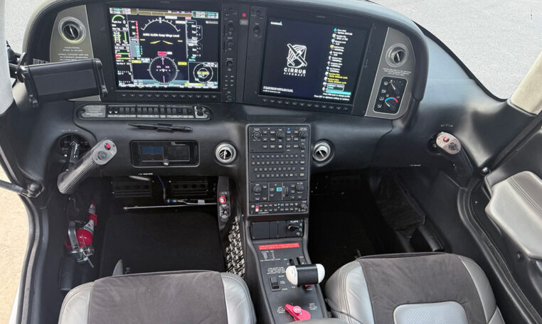 Cirrus SR22 airplane glass cockpit with dual Garmin Perspective displays, center keypad, side yokes, throttle quadrant.