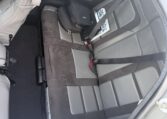 Clean gray and black leather car backseat with seat belts, two-tone rear bench in compact coupe, small bag on seat.