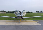 Cirrus SR22 parked on airport ramp, front view with open gullwing doors and three-blade propeller
