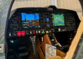 Modern glass cockpit avionics with dual Garmin displays in a general aviation aircraft instrument panel inside a hangar.